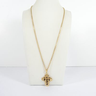 a gold necklace with a cross pendant on a mannequin neck
