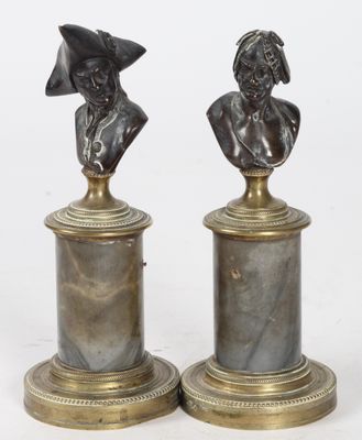 une paire de bustes en bronze représentant un homme et une femme, posés sur des socles