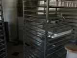 many trays of food that are on a rack in the kitchen