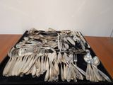 a lot of silverware on a tray on a table