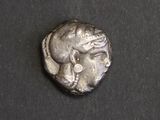 une pièce d'argent sur laquelle figure une femme assise sur une surface noire