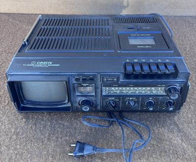 Une radio à l'ancienne est posée par terre à côté d'un chargeur branché
