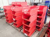 de nombreux bacs rouges empilés sur des palettes dans un entrepôt