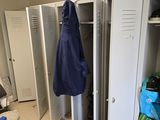 several lockers in a room with a blue coat hanging on the door