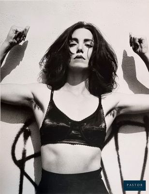 photographie en noir et blanc d'une femme vêtue d'un haut sans manches, les mains en l'air