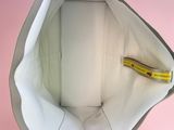 a bag with a banana in it on a pink background