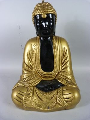 figurine de Bouddha assise sur une surface blanche, avec un fond blanc