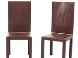 une paire de chaises de salle à manger en cuir marron avec des pieds en métal, sur fond blanc