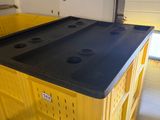 a yellow crate with a black top in a garage