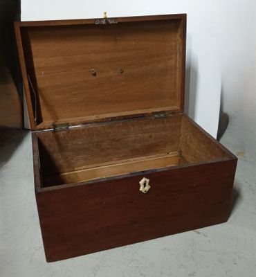 une caisse en bois ouverte, posée à même le sol