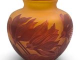 an orange vase with a floral design on it