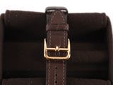 brown leather watch case with a gold buckle on a white background