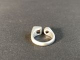 a silver ring with a hole in it on a table