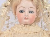 a close up of a doll with a veil on it