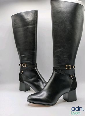 une paire de bottes en cuir noir avec des boucles sur les côtés