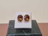 a pair of yellow sapphire earrings sitting on top of a marble block