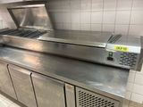 plan de travail en acier inoxydable dans une cuisine professionnelle équipée d'un grand four