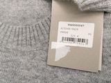 the label on a sweater is attached to the back of a sweater