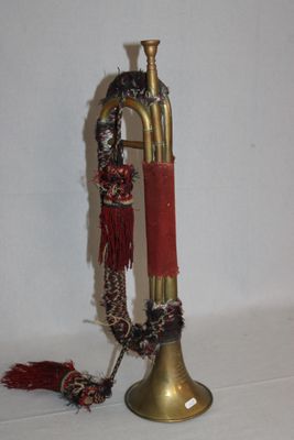 une trompette en laiton avec une poignée rouge sur un fond blanc