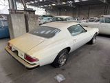 a white car parked in a garage with other cars in the background