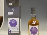 a bottle of whisky sitting next to a box of wine