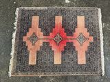 un tapis rouge et noir posé sur un sol en béton