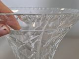 a person holding a glass vase on a table