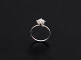 a close up of a diamond ring on a black surface