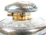 a silver vase with a glass lid on a table