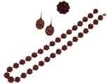 un gros plan d'un collier et de boucles d'oreilles sur fond blanc