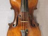 an old violin hanging on a wall with a bow on it ' s back