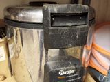 a silver and black blender sitting on a shelf in a kitchen