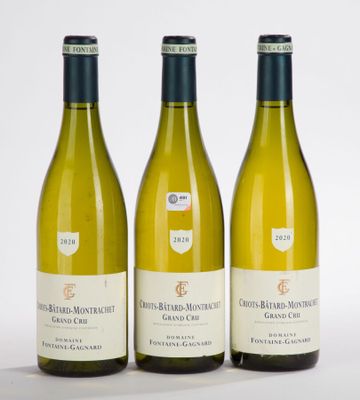 trois bouteilles de vin blanc posées l'une à côté de l'autre sur une surface blanche