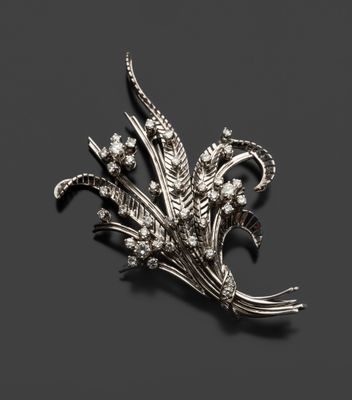 une broche en argent représentant des fleurs et des feuilles sur fond noir