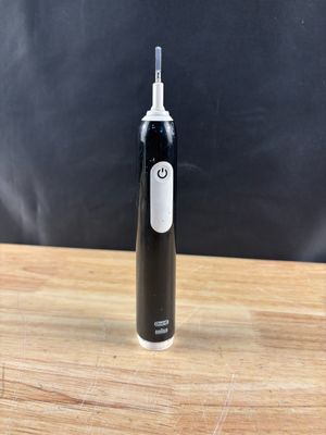 une brosse à dents électrique posée sur une table en bois