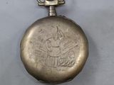 an old silver pocket watch with a picture of a woman on it