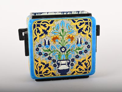 a small blue and yellow vase with flowers on it