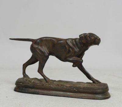 statue d'un chien en train de courir, posée sur un socle en bois, sur fond blanc