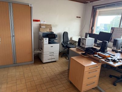 un bureau avec une imprimante posée dessus, dans une pièce