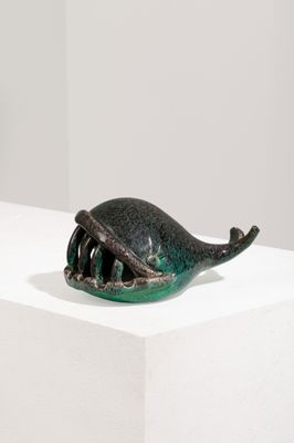 une petite sculpture représentant une baleine posée sur un socle blanc
