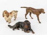 trois figurines de chiens posées sur une surface blanche, sur fond blanc