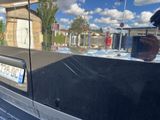 a reflection of a person taking a picture in a car window