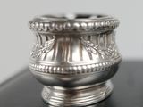 a silver vase sitting on top of a black table
