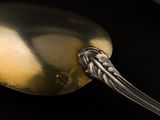 a spoon with a silver handle on a black surface