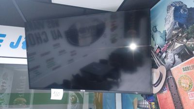 a flat screen tv hanging from the ceiling in a store