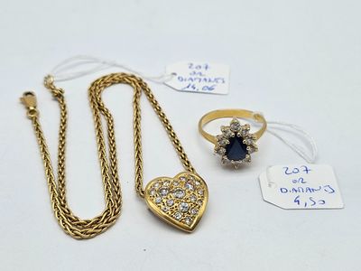 a close up of a necklace and a ring on a table