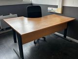 a desk with a chair and a window in the room