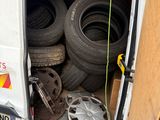 a white van with a bunch of tires in the back of it