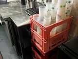 une pile de gobelets en plastique posée sur une caisse rouge