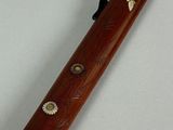 a small wooden pipe with flowers on it on a white surface